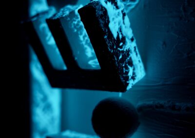 Night view of PAGE ZERO with photoluminescent pigments activating the central gap, transforming the space into a glowing origin of light and structure.