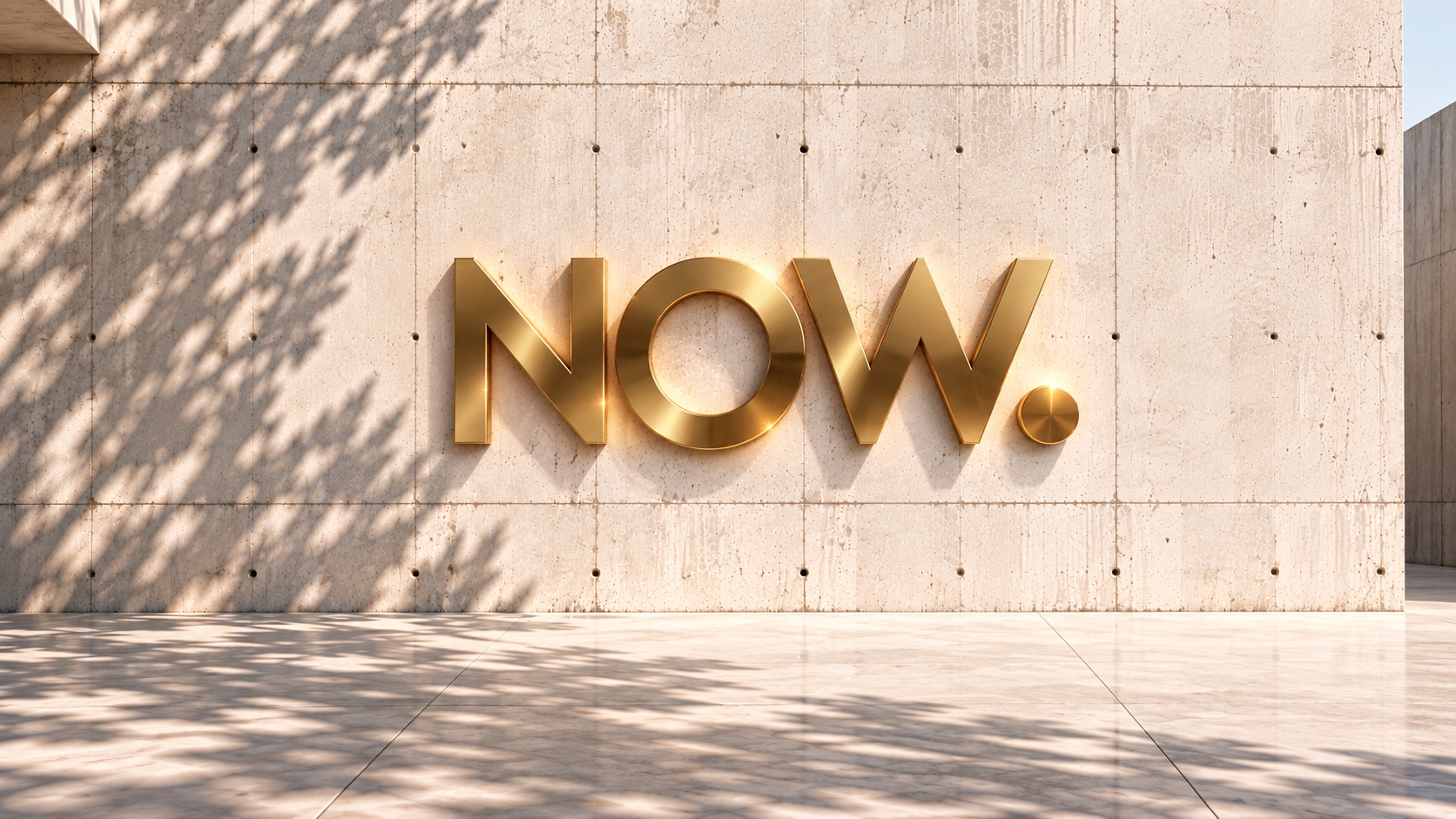 Golden 3D lettering “NOW.” on a minimalist concrete wall with soft natural shadows — K-NY, Universe II.
